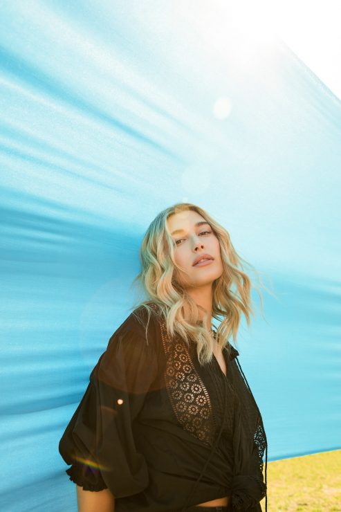 海莉身著LEVI’S® 綴有蕾絲織紋與流蘇綁繩細節的黑色公主蓬袖上衣，搭配同色系破損設計501® 丹寧貼身五分褲，率性又浪漫的風貌，絕對是今夏女孩們最時髦的穿搭示範！_2